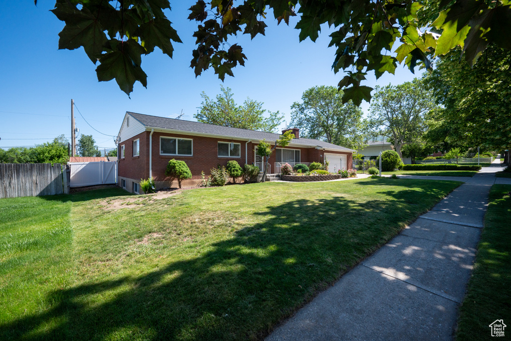 Single story home with an attached garage, brick siding, and a chimney