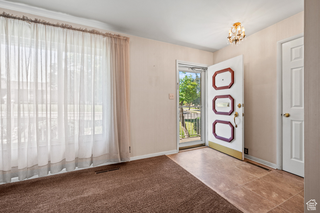 Entryway with a chandelier, baseboards, and tile patterned floors