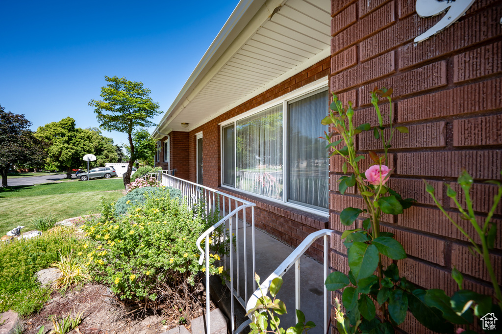 View of property exterior featuring brick siding and a lawn