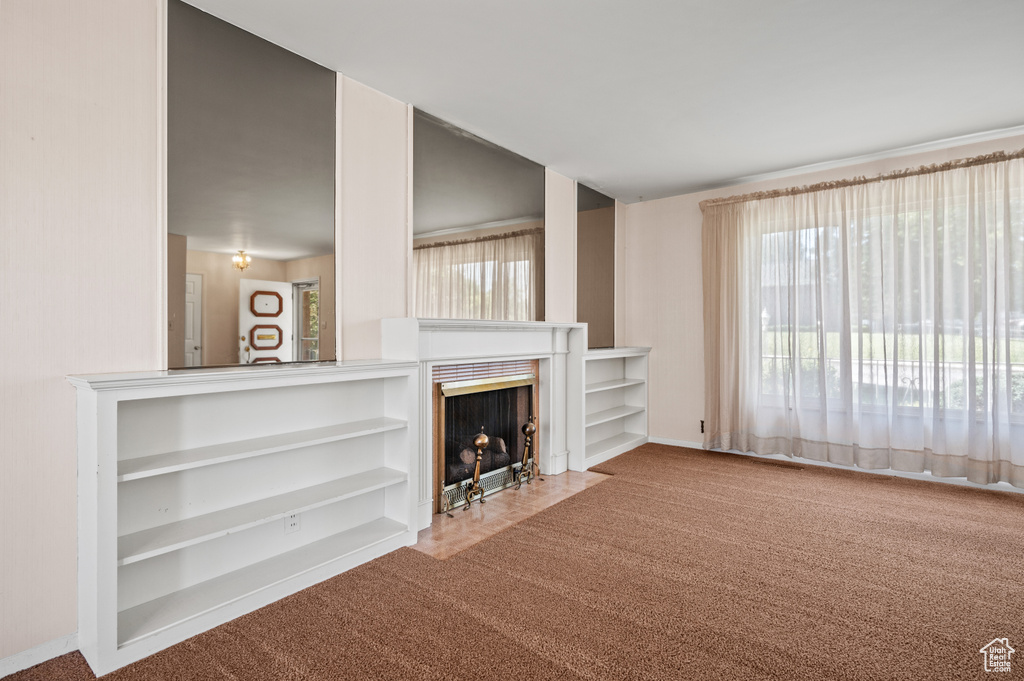 Carpeted living room featuring a fireplace with flush hearth and baseboards