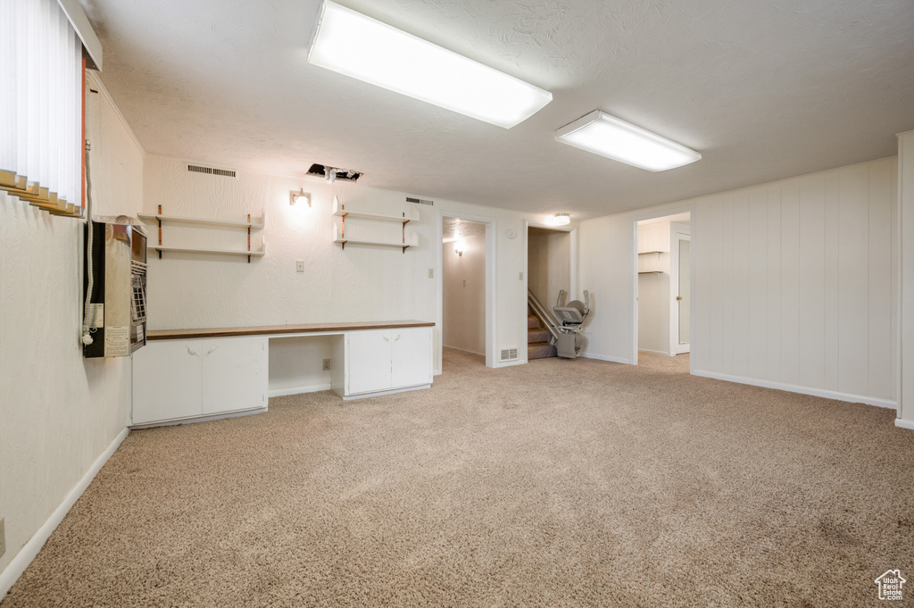 Finished basement with carpet flooring, stairway, and baseboards