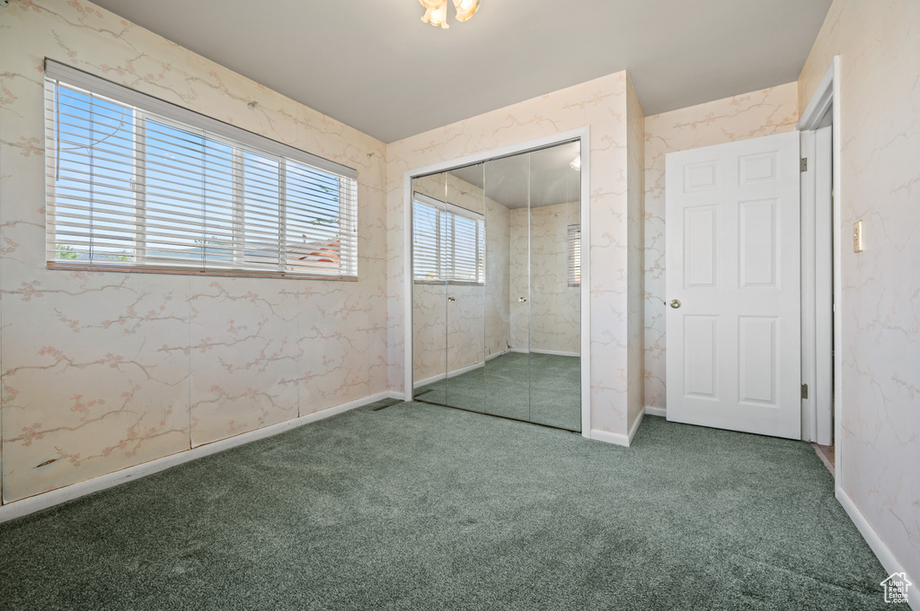 Unfurnished bedroom featuring carpet floors, a closet, and baseboards