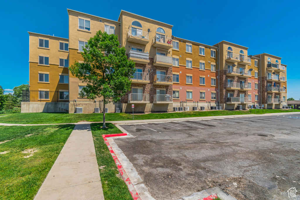 View of apartment building / complex featuring uncovered parking