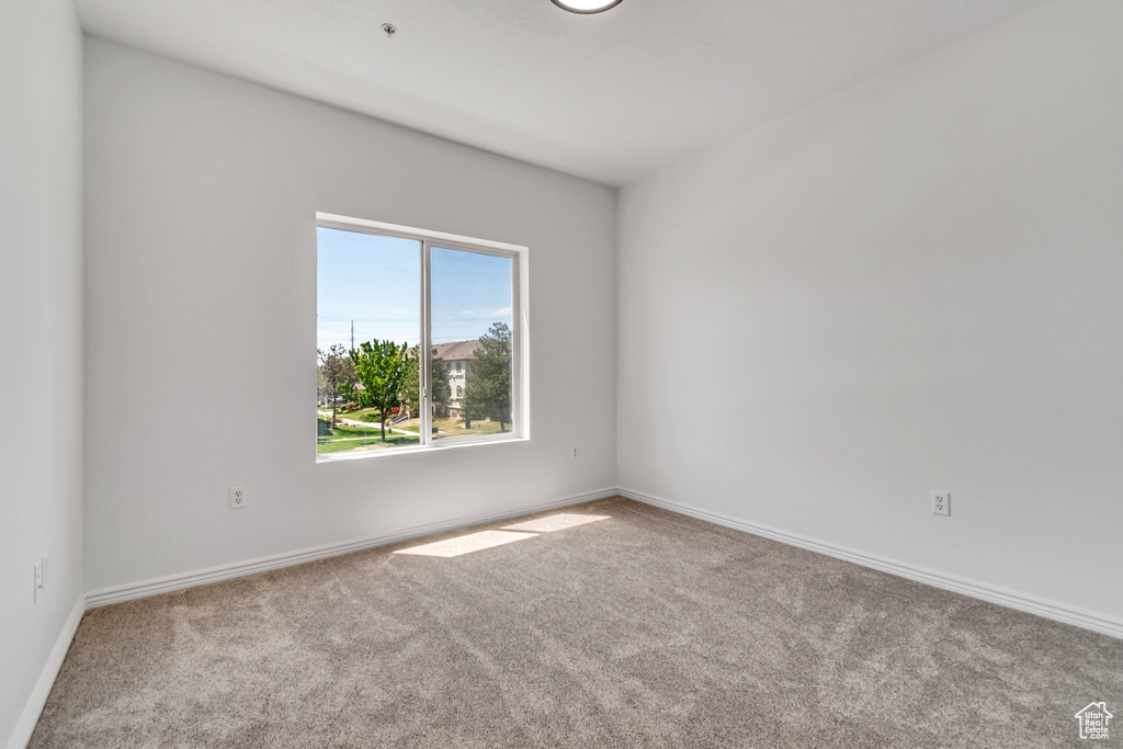 Empty room featuring carpet and baseboards