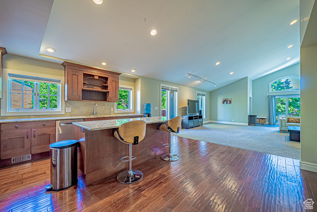 Kitchen with stainless steel dishwasher, a sink, open floor plan, hardwood / wood-style floors, and open shelves