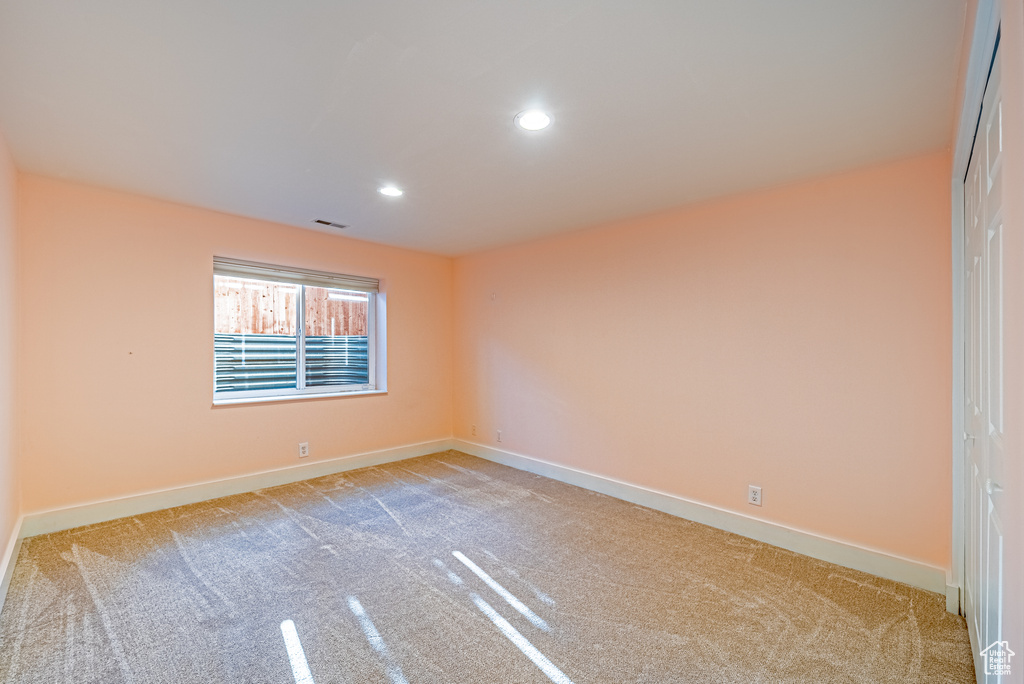 Unfurnished room featuring light colored carpet, baseboards, and recessed lighting