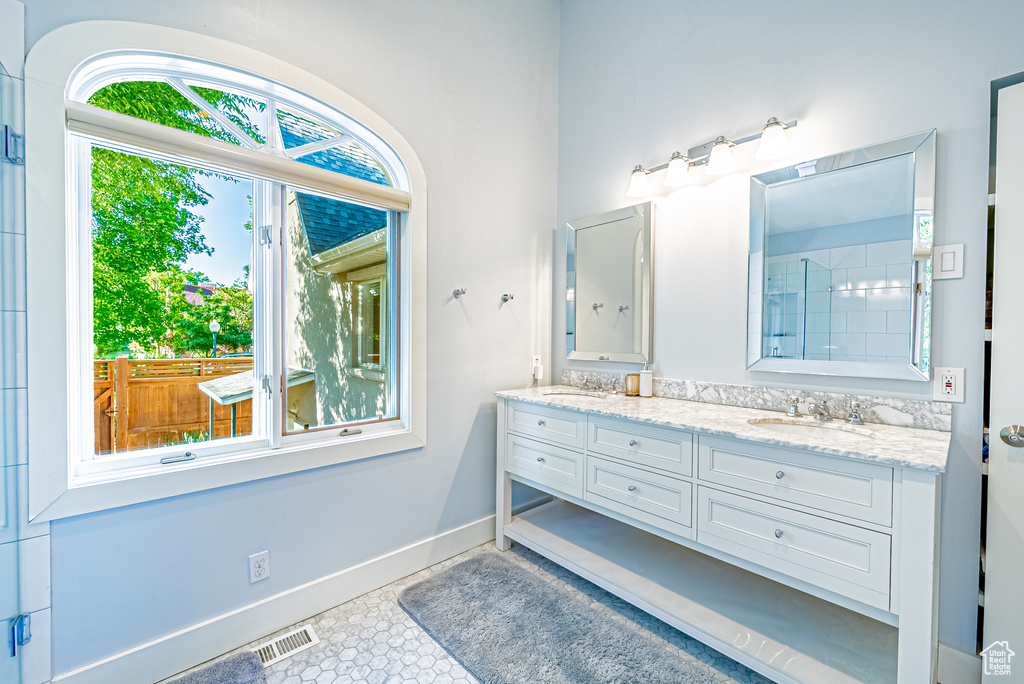 Bathroom with double vanity and baseboards