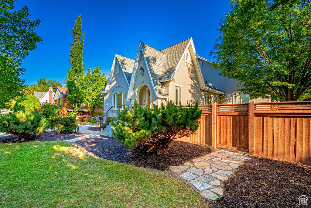 View of side of home featuring a shingled roof and stucco siding