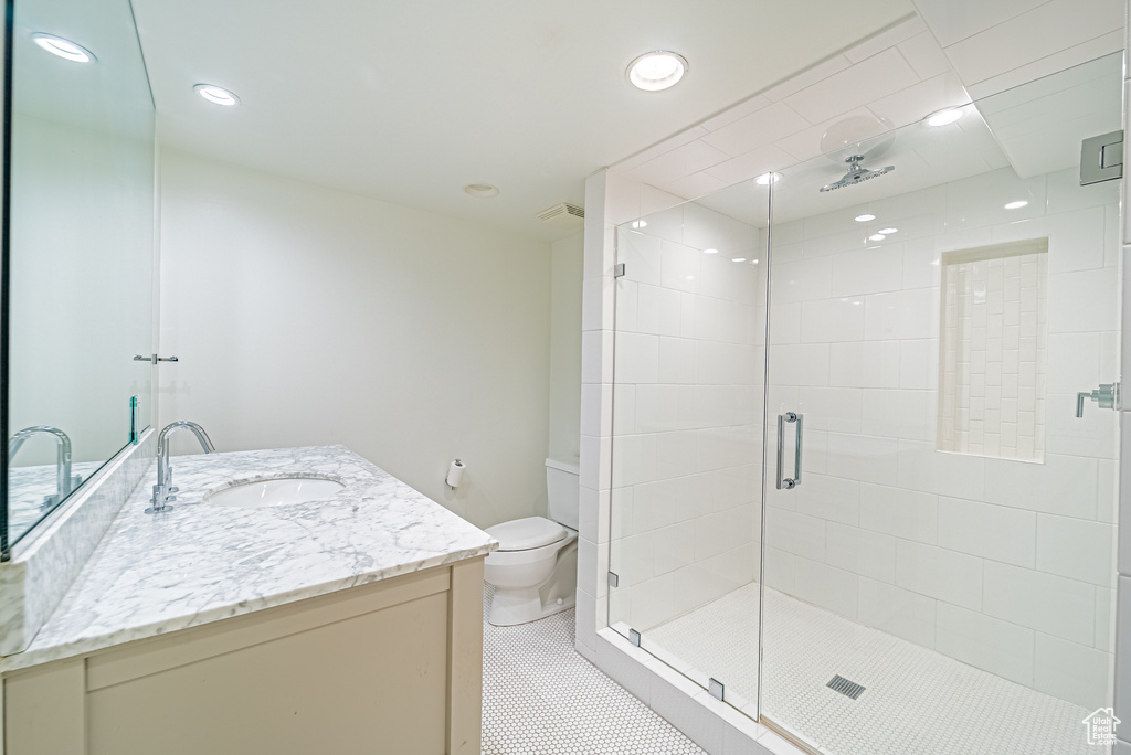 Full bath featuring vanity, a shower stall, toilet, recessed lighting, and tile patterned floors