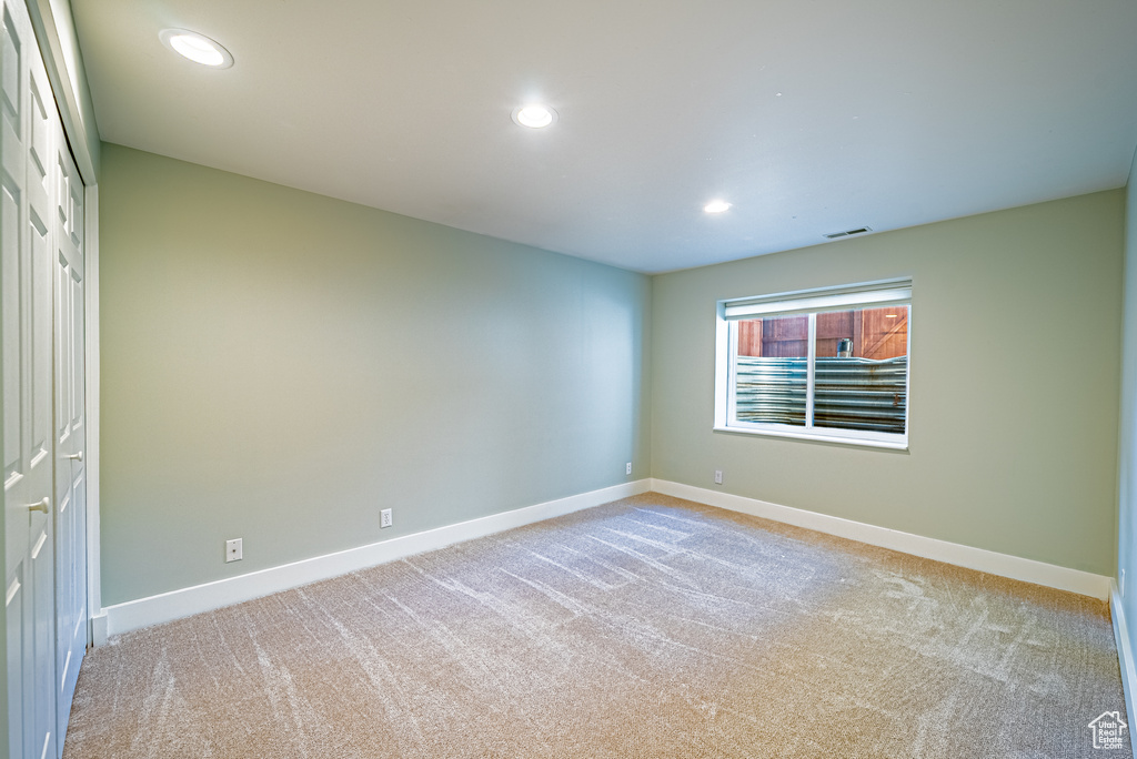 Unfurnished room featuring light carpet, baseboards, and recessed lighting