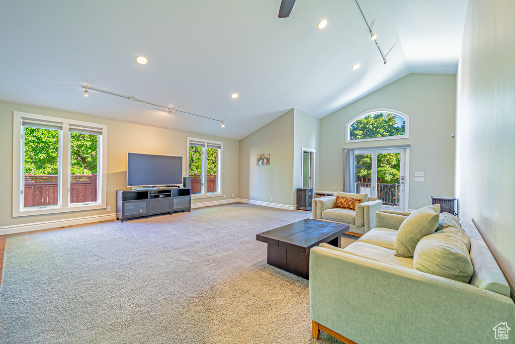 Carpeted living room featuring lofted ceiling, recessed lighting, baseboards, and ceiling fan