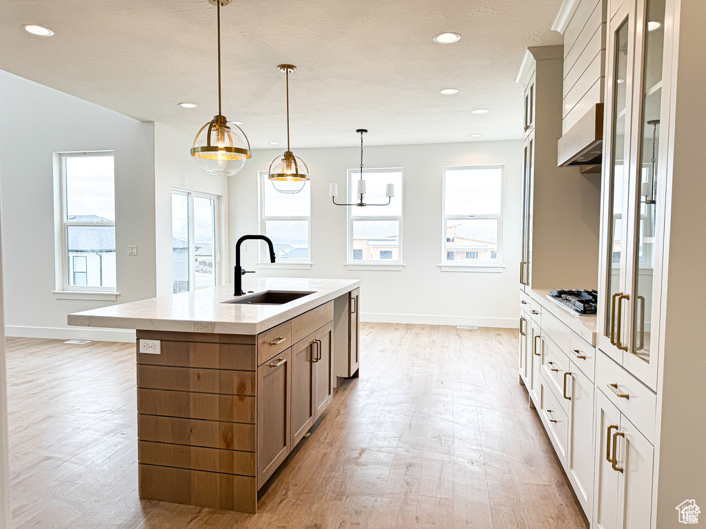 Kitchen featuring a sink, light wood-style flooring, stainless steel gas stovetop, baseboards, and recessed lighting