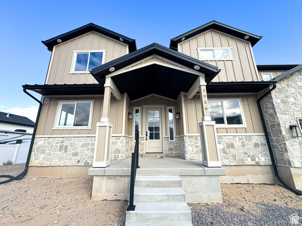 View of front of house with stone siding and board and batten siding