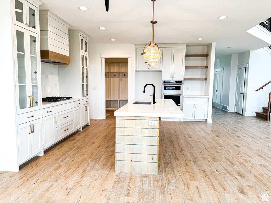 Kitchen featuring a sink, appliances with stainless steel finishes, open shelves, baseboards, and recessed lighting