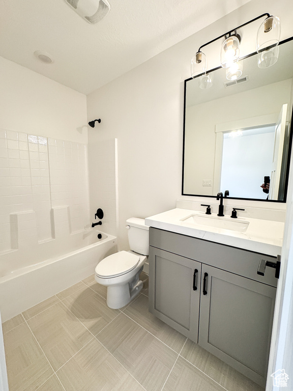Bathroom with toilet, vanity, bathtub / shower combination, and tile patterned floors