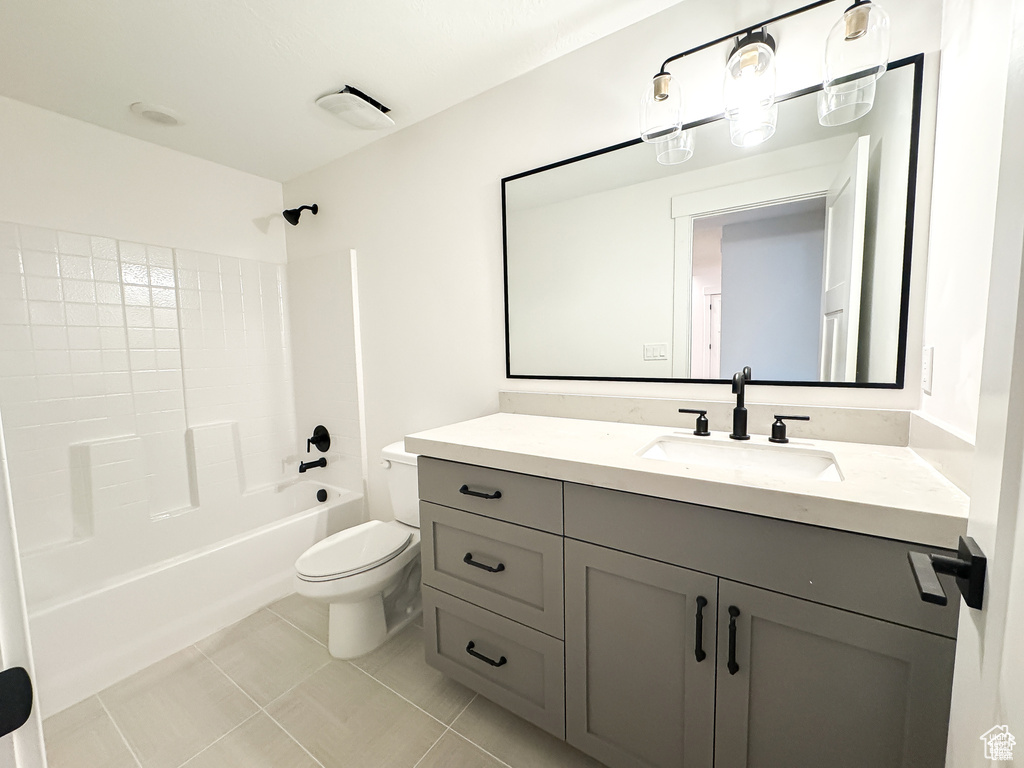 Bathroom with vanity, toilet, tile patterned floors, and shower / bath combination