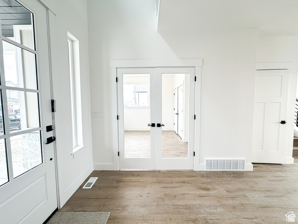 Foyer featuring wood finished floors, french doors, and baseboards