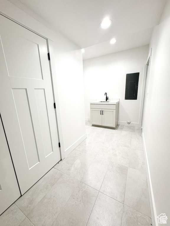 Hall featuring electric panel, a sink, recessed lighting, and baseboards
