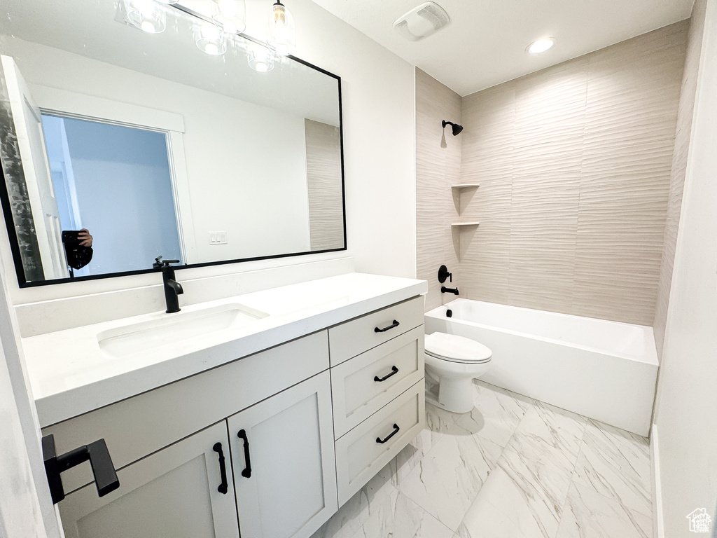 Full bathroom featuring vanity, toilet, marble finish floors,  shower combination, and recessed lighting