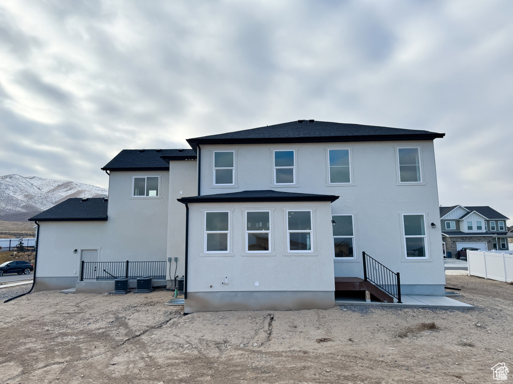Rear view of property with stucco siding and a mountain view