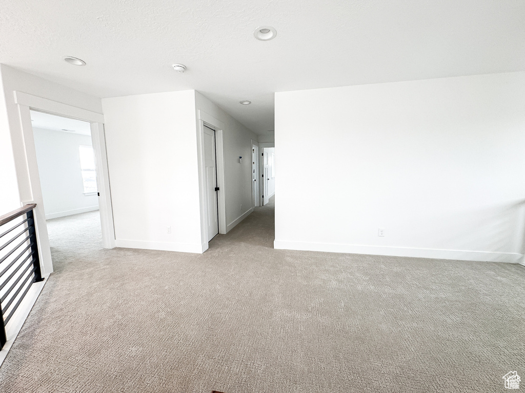 Spare room with light colored carpet, baseboards, and recessed lighting