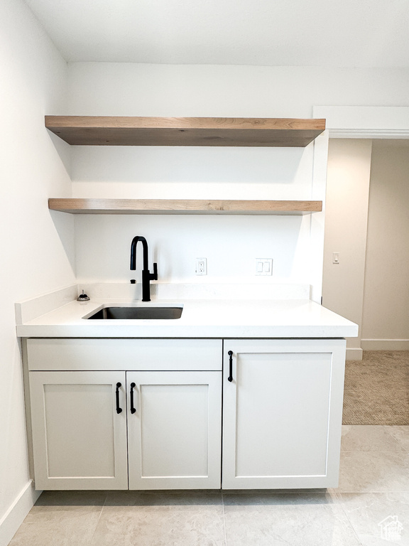 Bar area featuring a sink and baseboards