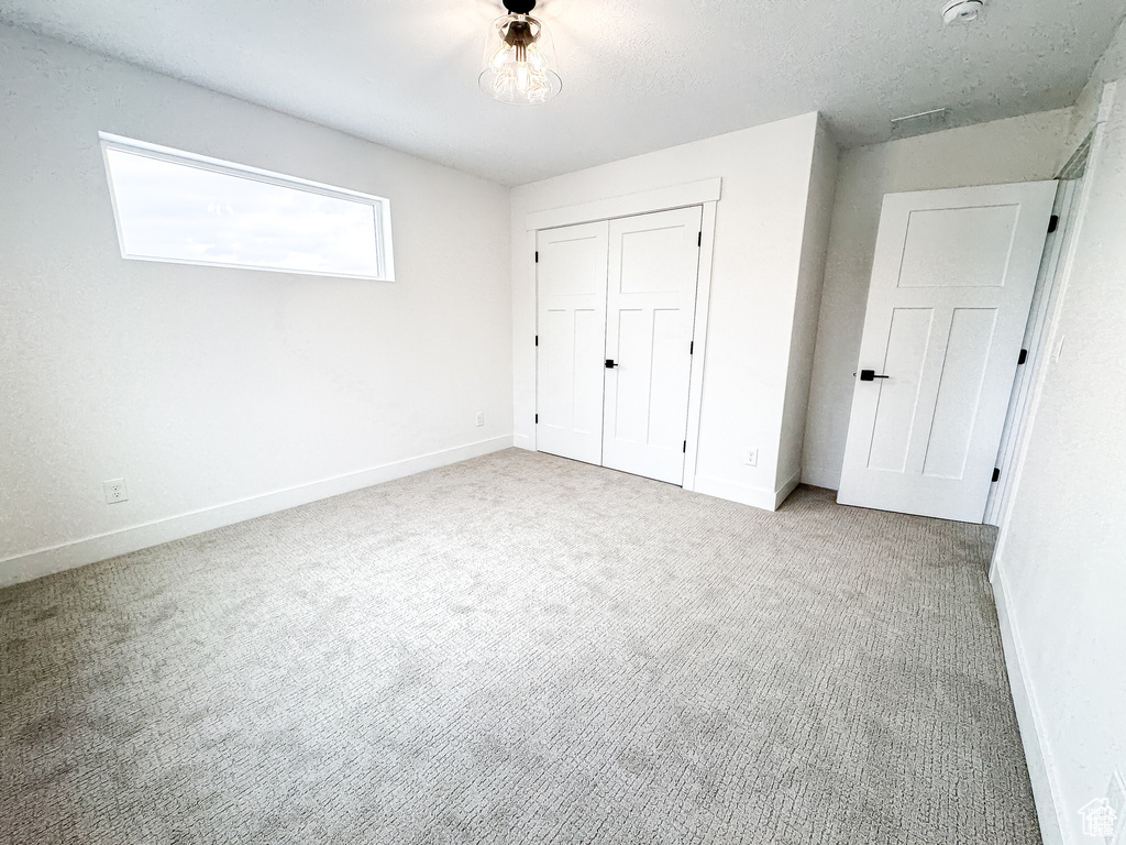 Unfurnished bedroom with carpet floors, baseboards, and a closet