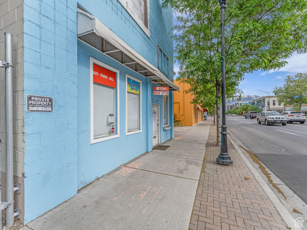 View of asphalt street featuring sidewalks, street lighting, and curbs