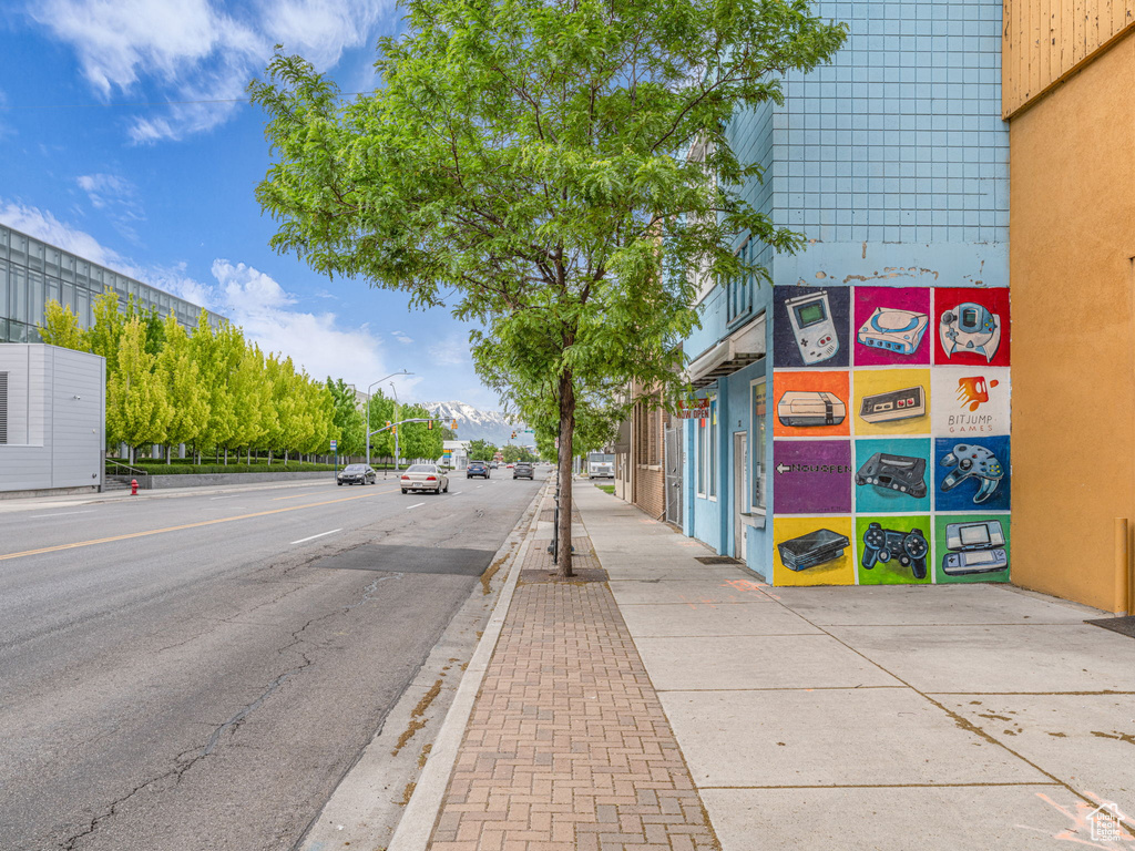 View of asphalt street featuring sidewalks, street lights, and curbs
