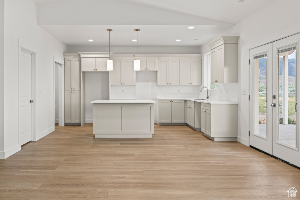 Kitchen featuring a sink, recessed lighting, a kitchen island, and light wood finished floors