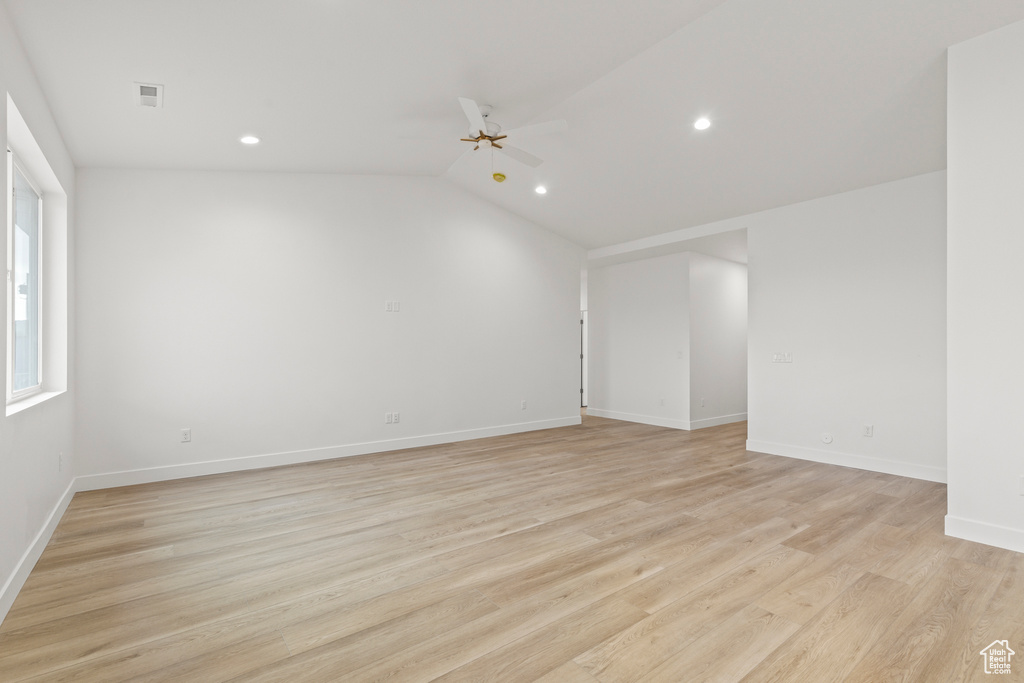 Spare room featuring recessed lighting, a ceiling fan, light wood-type flooring, vaulted ceiling, and baseboards