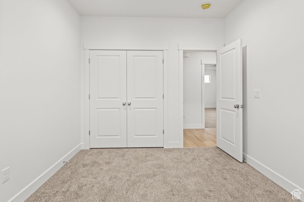Unfurnished bedroom featuring carpet floors, baseboards, and a closet