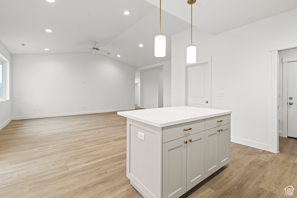 Kitchen featuring a ceiling fan, recessed lighting, a center island, lofted ceiling, and light wood finished floors