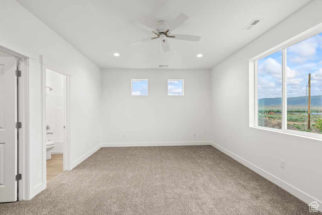Unfurnished bedroom featuring carpet flooring, multiple windows, baseboards, and recessed lighting