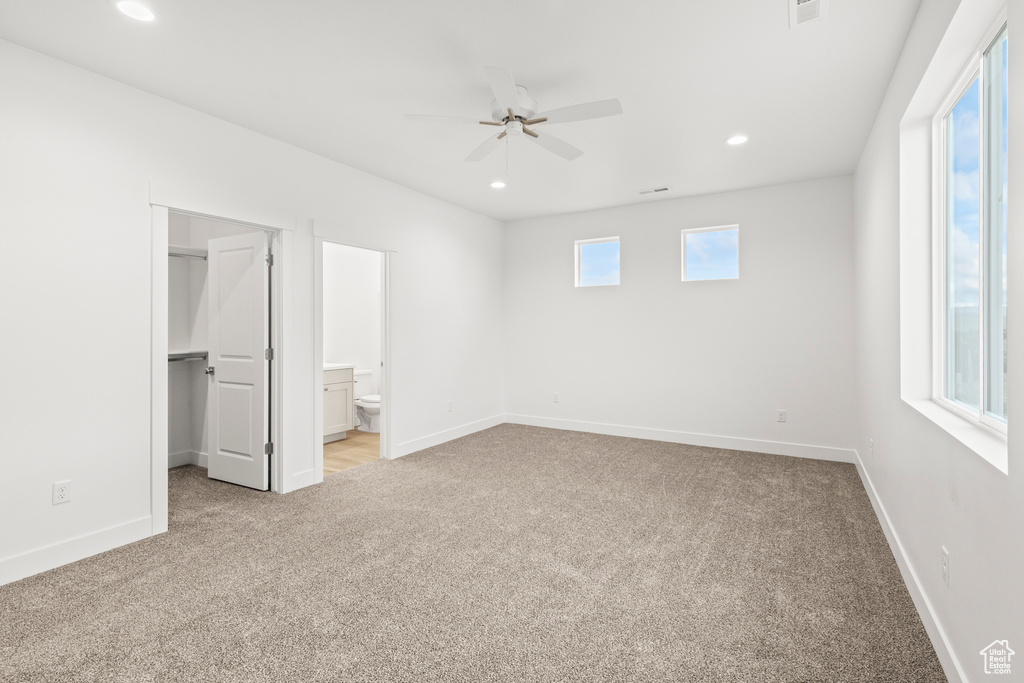 Unfurnished bedroom with carpet floors, a spacious closet, baseboards, and recessed lighting