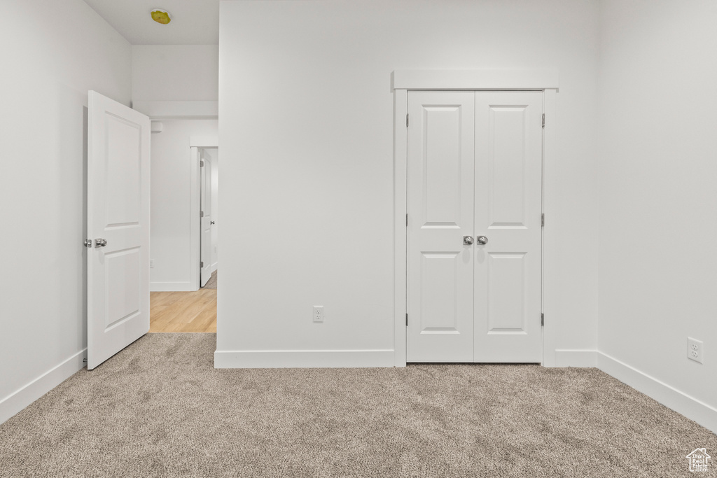 Unfurnished bedroom featuring carpet flooring, baseboards, and a closet
