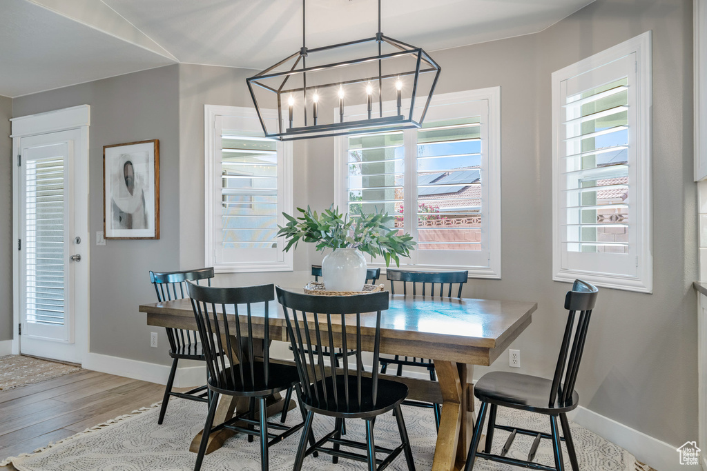 Dining space featuring a chandelier, baseboards, and wood finished floors
