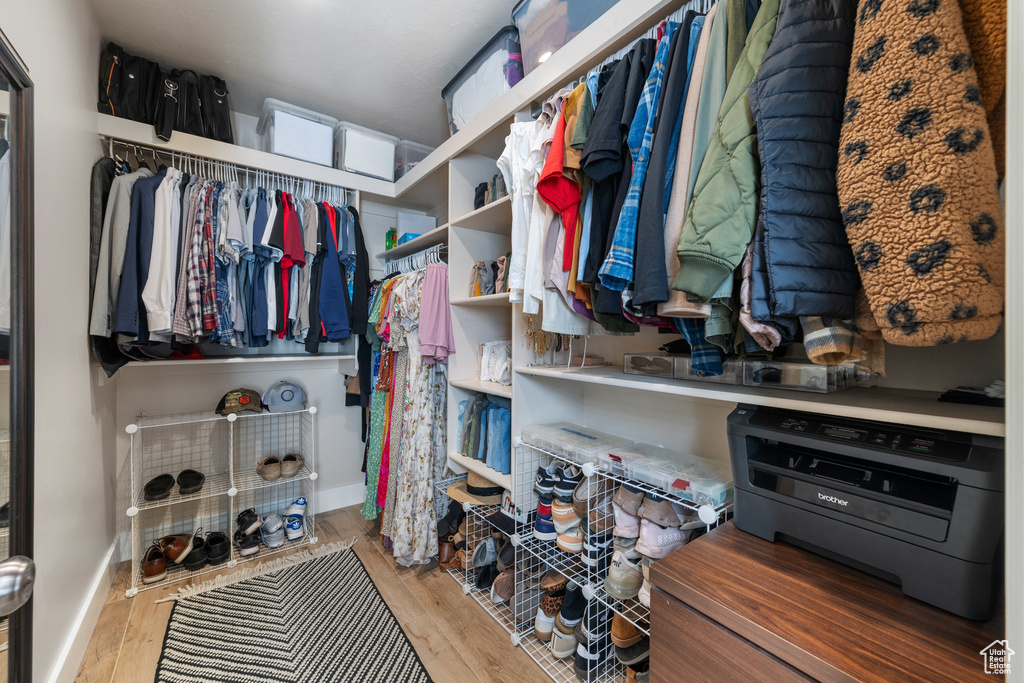 Walk in closet with wood finished floors