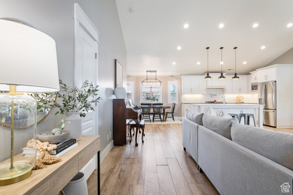 Living room featuring light wood finished floors, recessed lighting, and baseboards