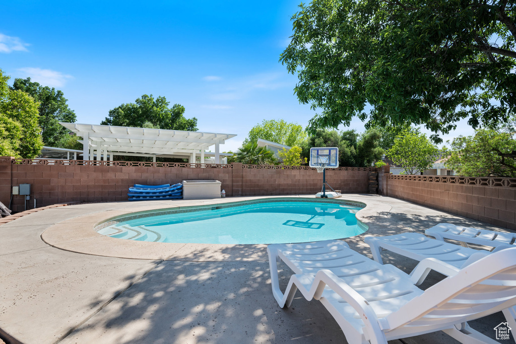 View of pool featuring a pergola, a fenced backyard, and a patio