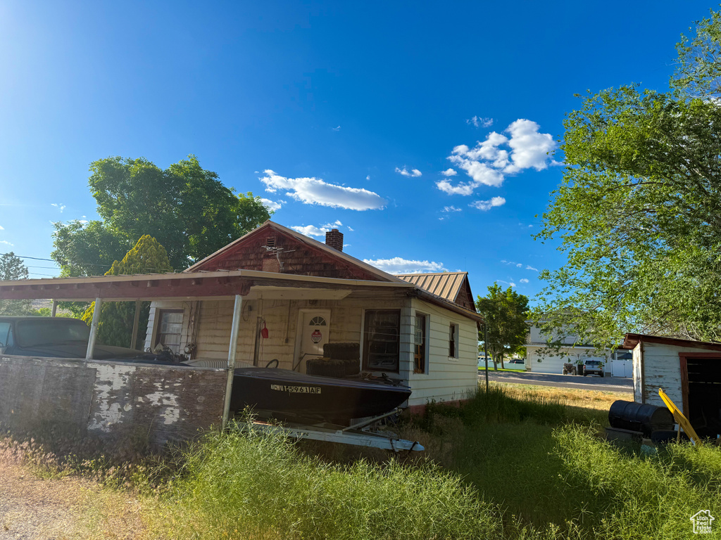 View of front of property featuring a chimney and metal roof