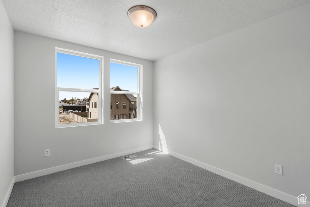 Carpeted empty room featuring baseboards