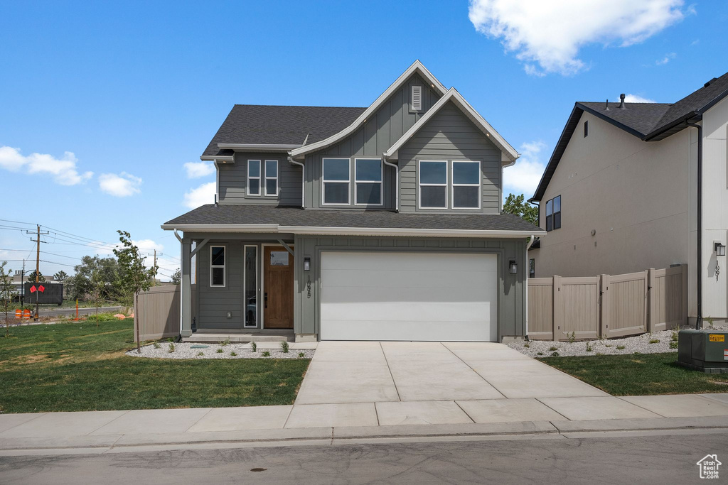 Craftsman inspired home with a garage, driveway, and board and batten siding
