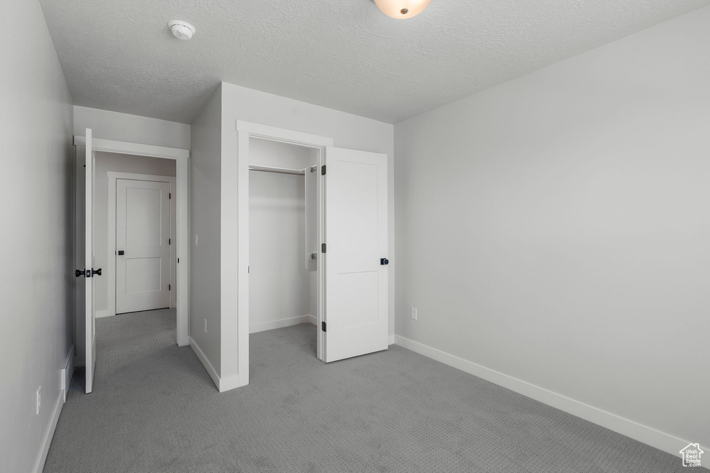 Unfurnished bedroom featuring carpet, baseboards, a closet, and a spacious closet