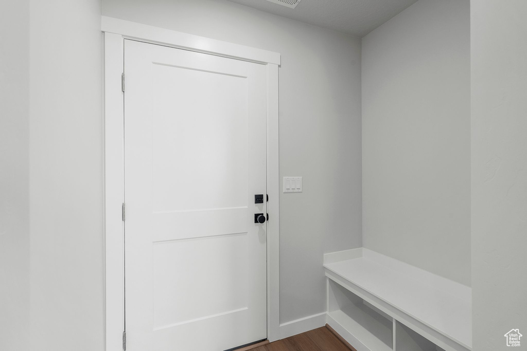Mudroom with dark wood finished floors and baseboards