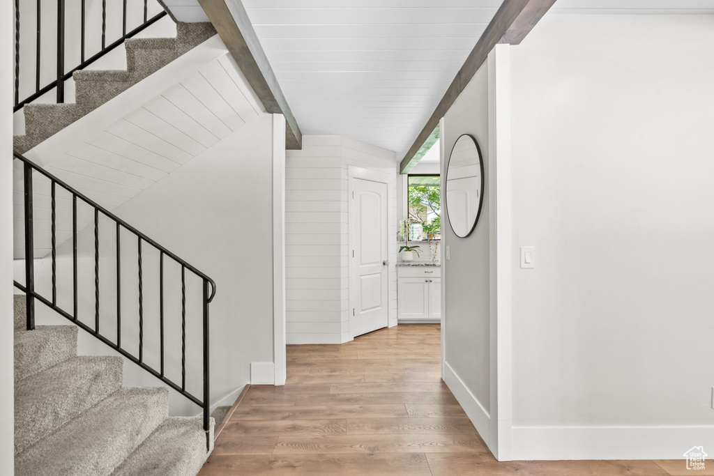 Entrance foyer featuring light wood-type flooring, stairs, and baseboards