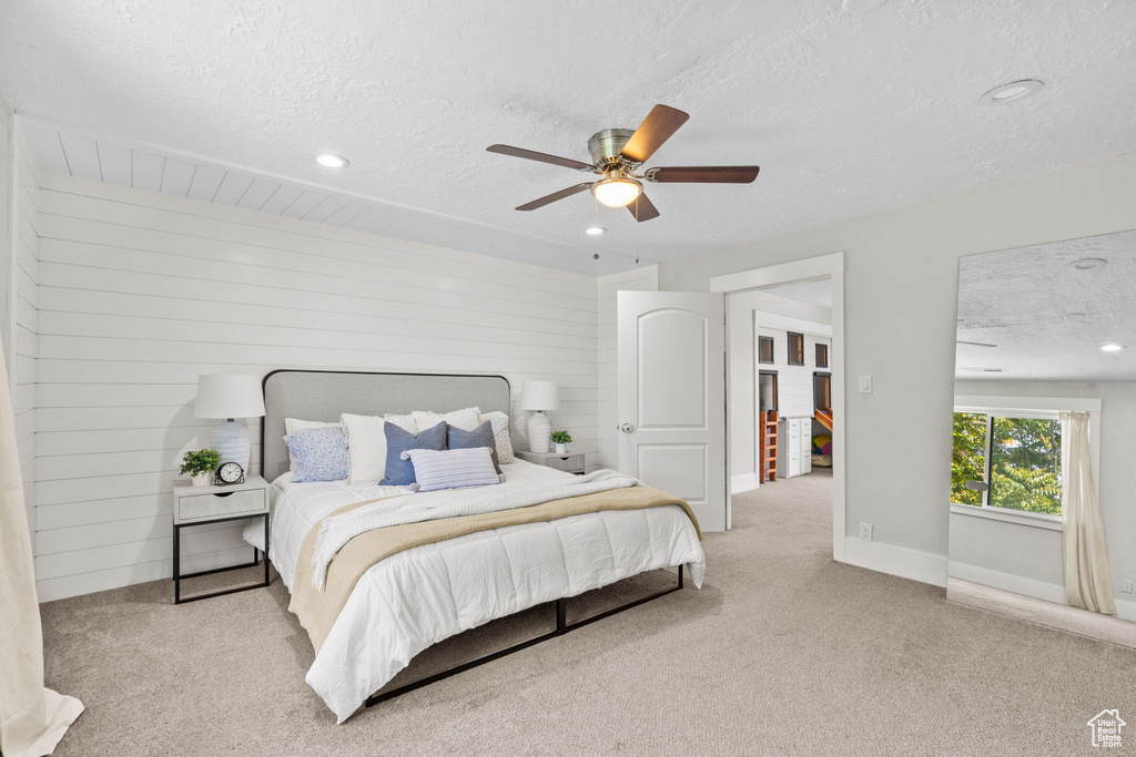 Carpeted bedroom featuring a textured ceiling, recessed lighting, a ceiling fan, and baseboards