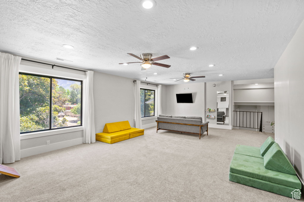Recreation room with carpet, recessed lighting, a textured ceiling, baseboards, and ceiling fan