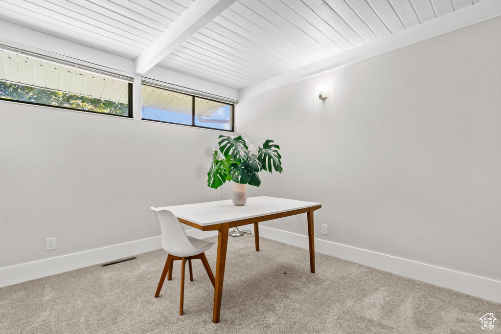 Office area featuring carpet, baseboards, and wood ceiling with exposed beams