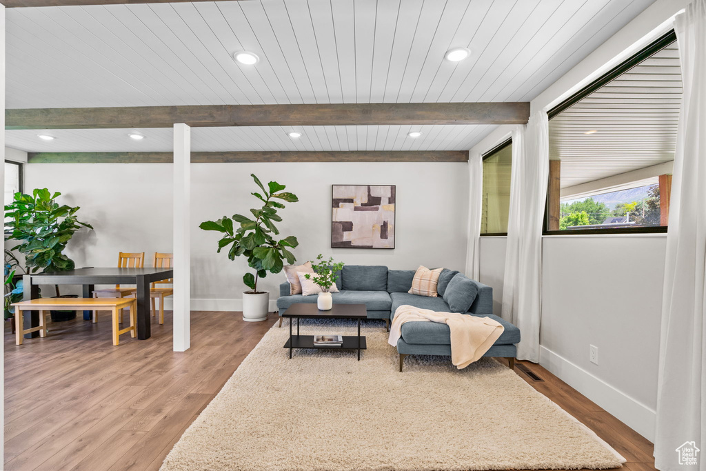 Living room with baseboards, wood finished floors, wood ceiling with exposed beams, and recessed lighting